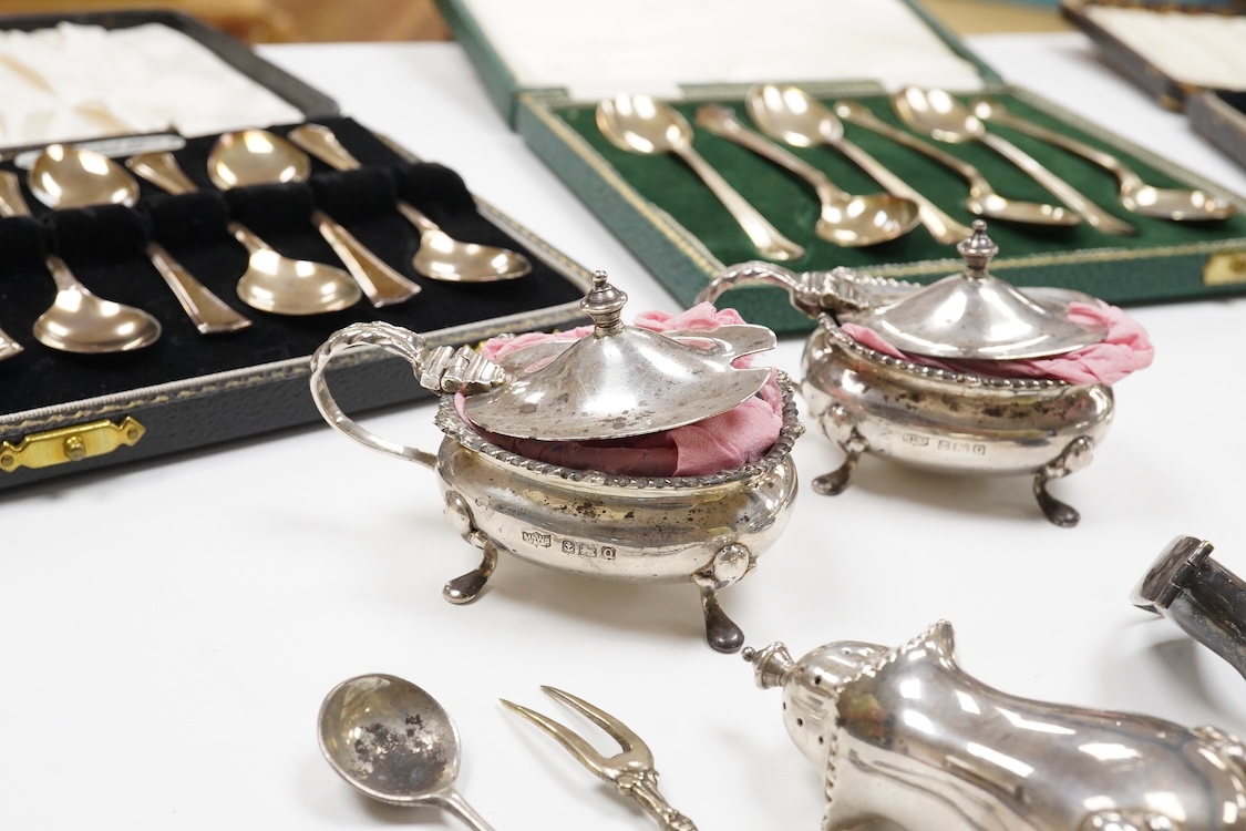 A collection of silver and white metal to include a 19th century Indian dressing table pot and cover chased with flowers, a three piece silver condiment set by Mappin and Webb with associated condiment spoon, three cased